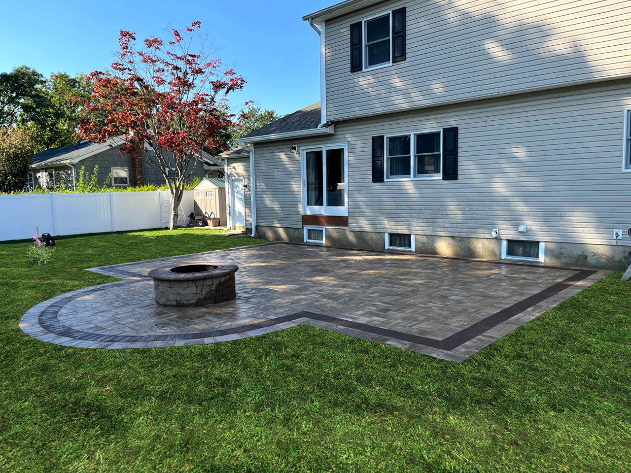 A flagstone patio features a stone-edged fire pit in one corner, great for gathering around on cool evenings.