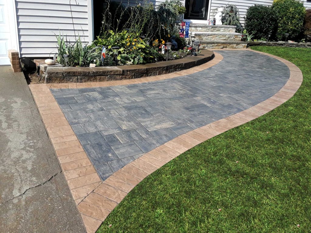 Paver walkway installation. A well-designed walkway in an outdoor patio, featuring stepping stones and a decorative pathway