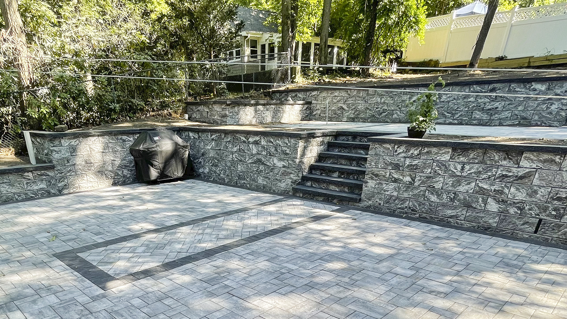 Cost-efficient natural stone retaining wall next to a patio