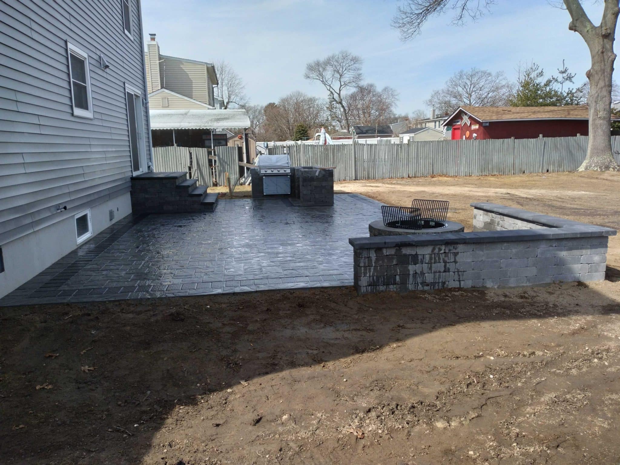 Stacked natural stone retaining walls surround a lush garden, creating a beautiful backdrop for the backyard.