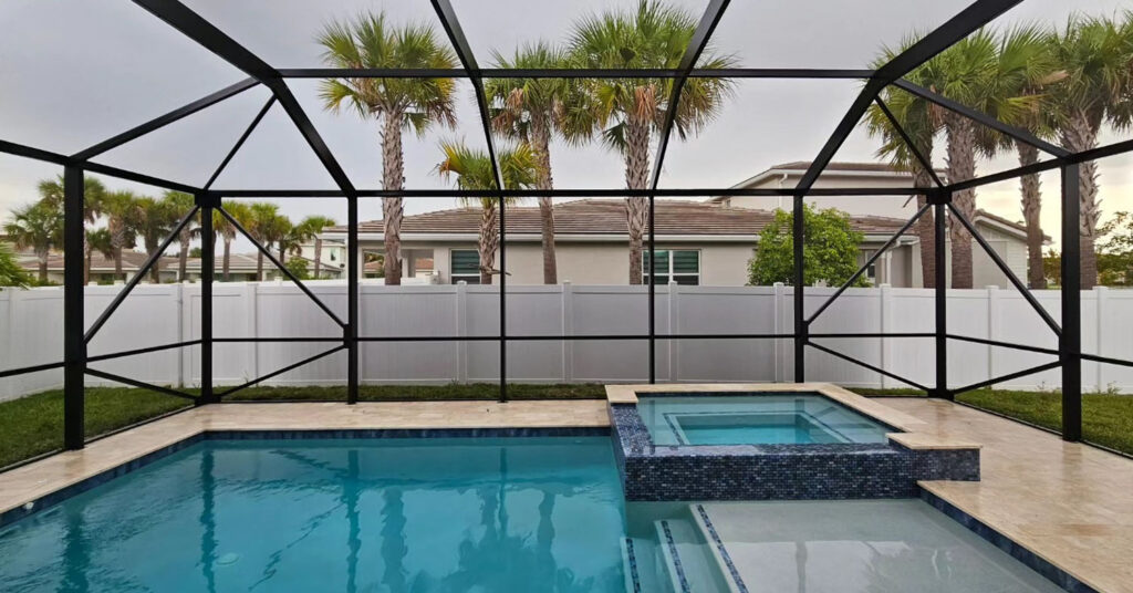 Modern pool with spa surrounded by a black aluminum frame, showing a clean and structured layout ideal for a DIY pool screen enclosure in Florida.