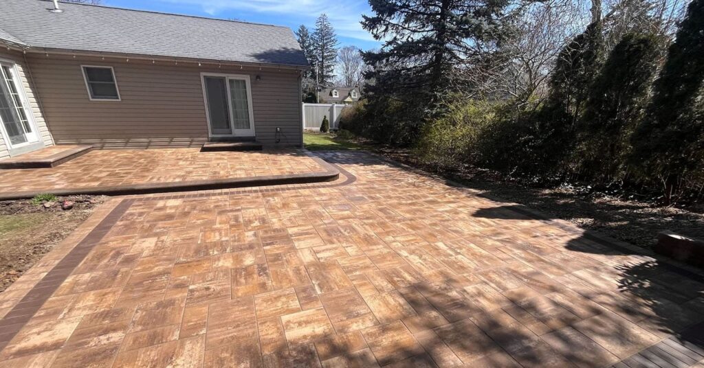 Spacious backyard with a new paver patio installation showing design quality and size variations that influence patio cost per square foot in Suffolk County.