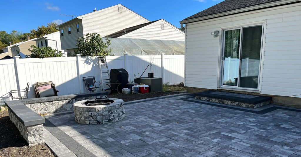 A beautiful circular fire pit or fire feature serves as the centerpiece for outdoor gatherings.