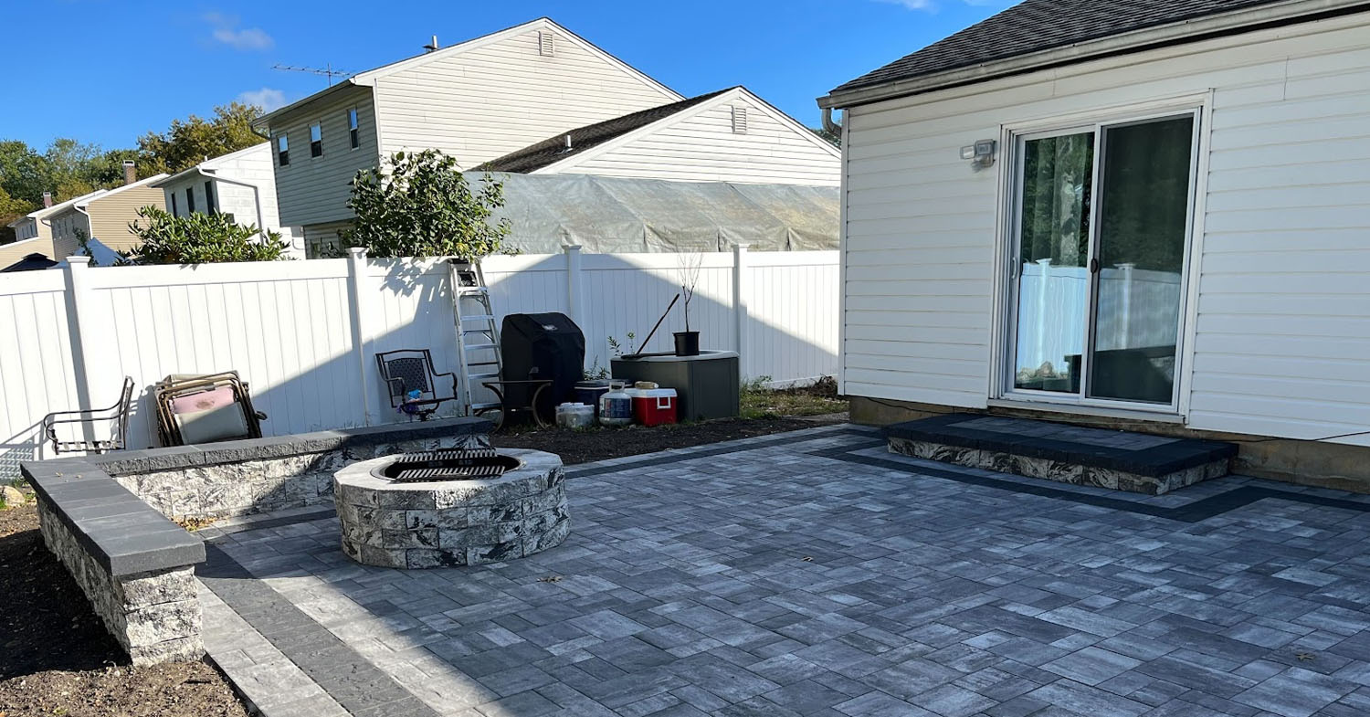 A beautiful circular fire pit or fire feature serves as the centerpiece for outdoor gatherings.