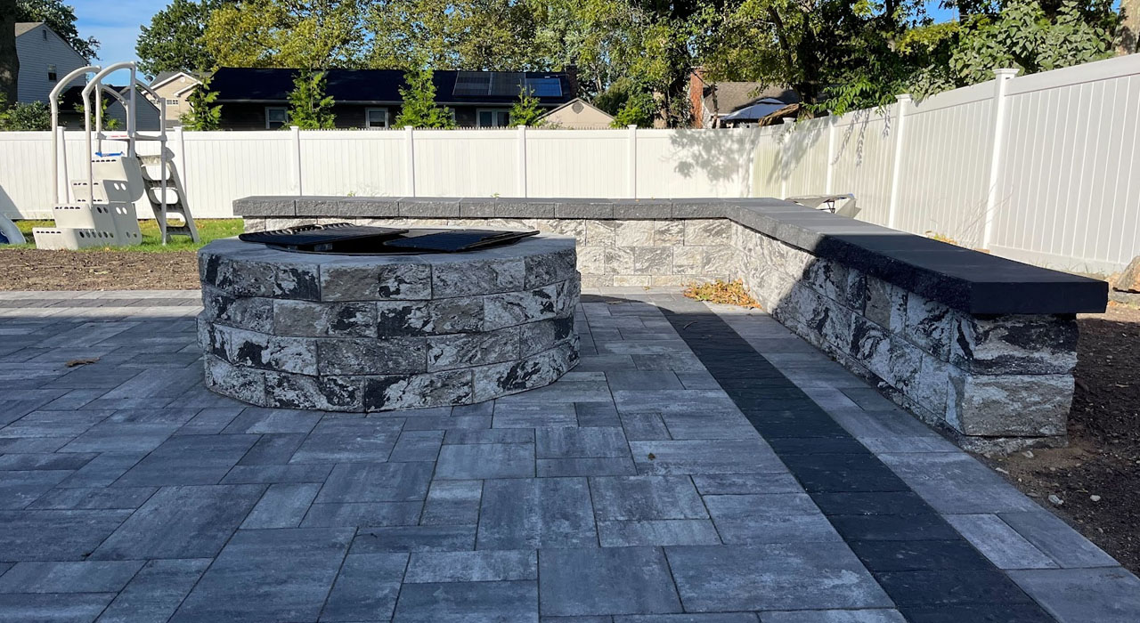 Low stone seating walls surround a custom circular pit, creating a cozy and functional area.