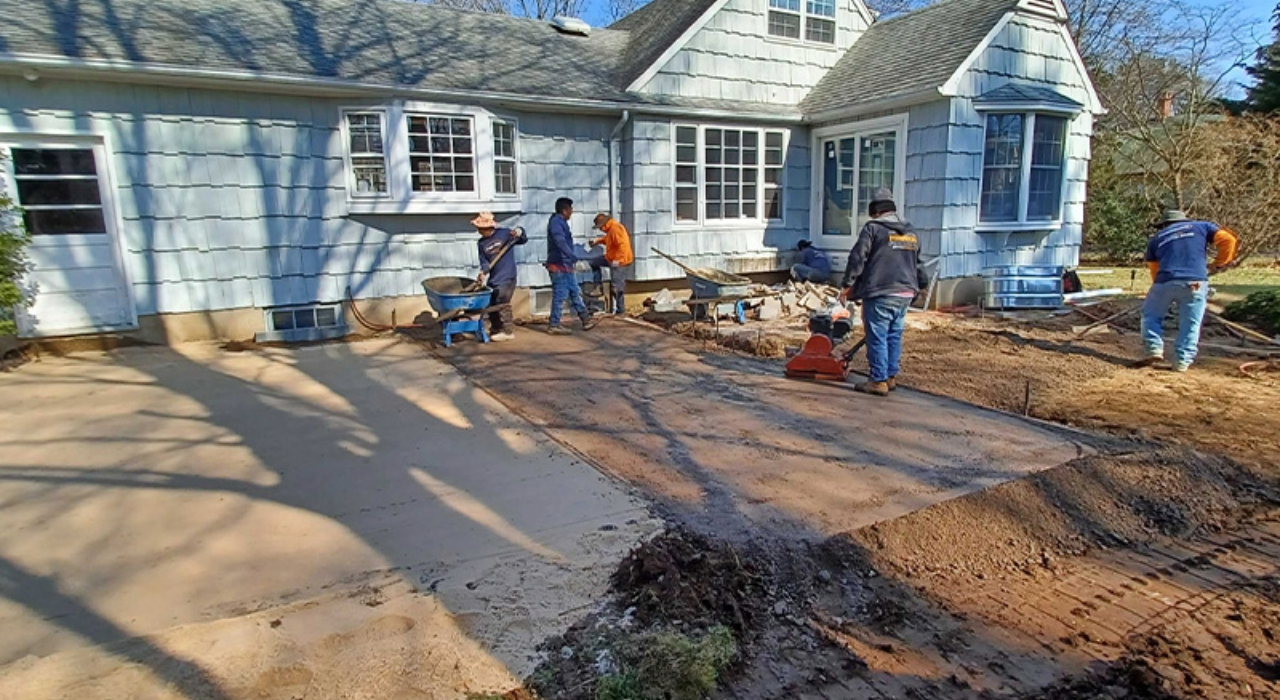 Construction crew leveling a sand base for a large patio.