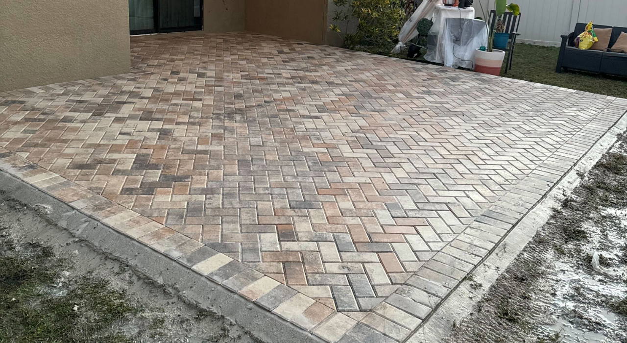 A completed herringbone pattern paver installation by Affordable Patio Florida, showcasing high-quality and affordable patios for modern backyard living.