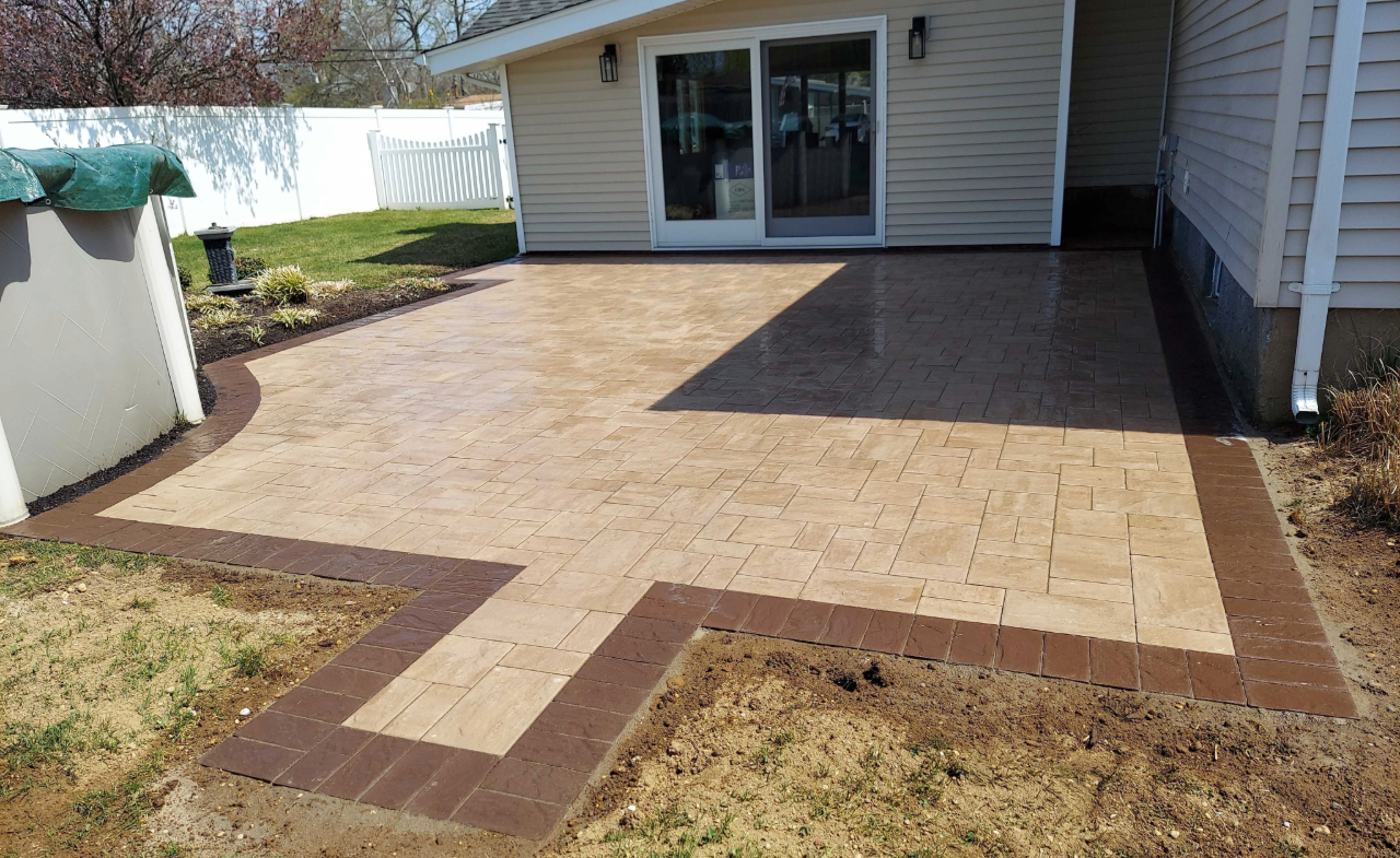 An expert patio installer carefully setting interlocking stones to create a durable and perfectly level backyard seating area.