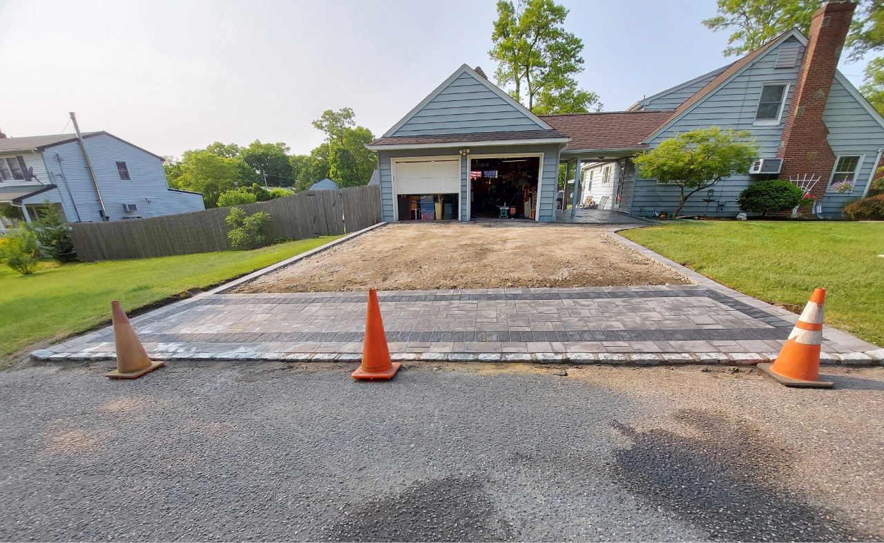 Construction site featuring a stone apron, a primary factor in the total cost to install a paver driveway.