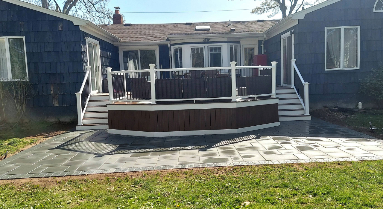 A stone surface integrated with a raised wooden deck, providing functional backyard enclosed patio design ideas.