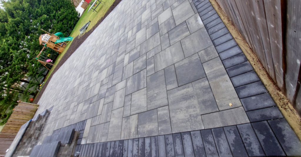 A beautiful stone paver patio featuring high-end outdoor furniture, illustrating factors that influence the patio cost in Nassau County.