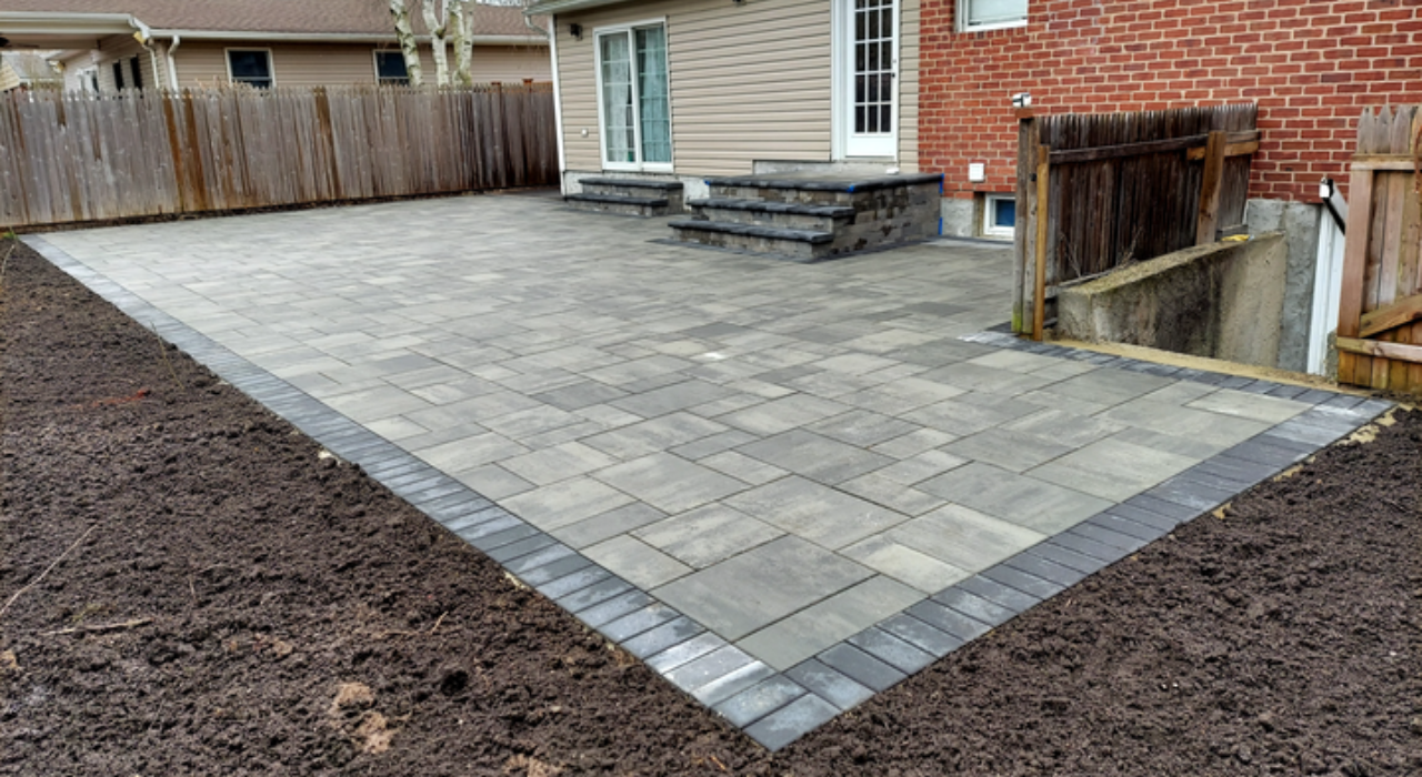 A spacious backyard patio featuring a brick retaining wall, providing context for homeowners researching the patio cost in Nassau County.