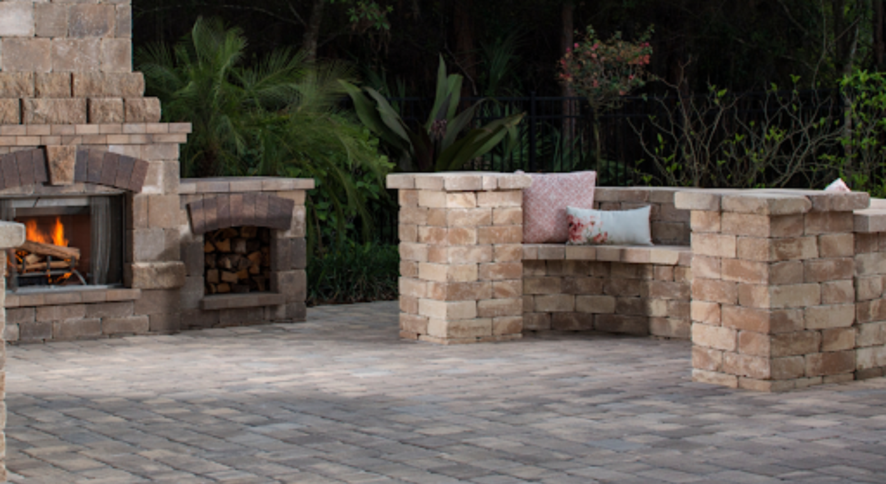 A spacious herringbone paver surface with seating and a fire pit, a key element of outdoor kitchen and patio design.