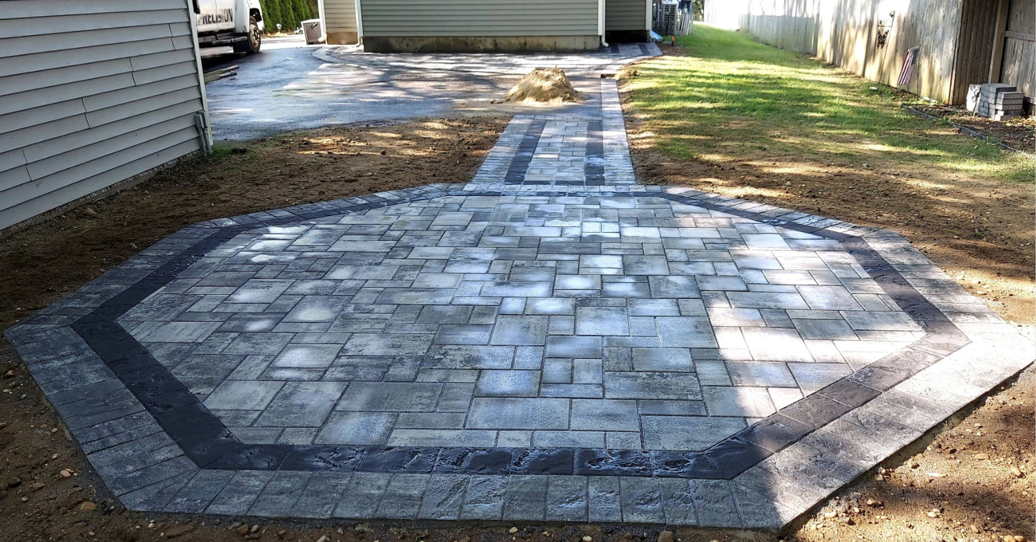 A large octagonal stone surface in a backyard, providing a functional foundation for outdoor living space ideas.