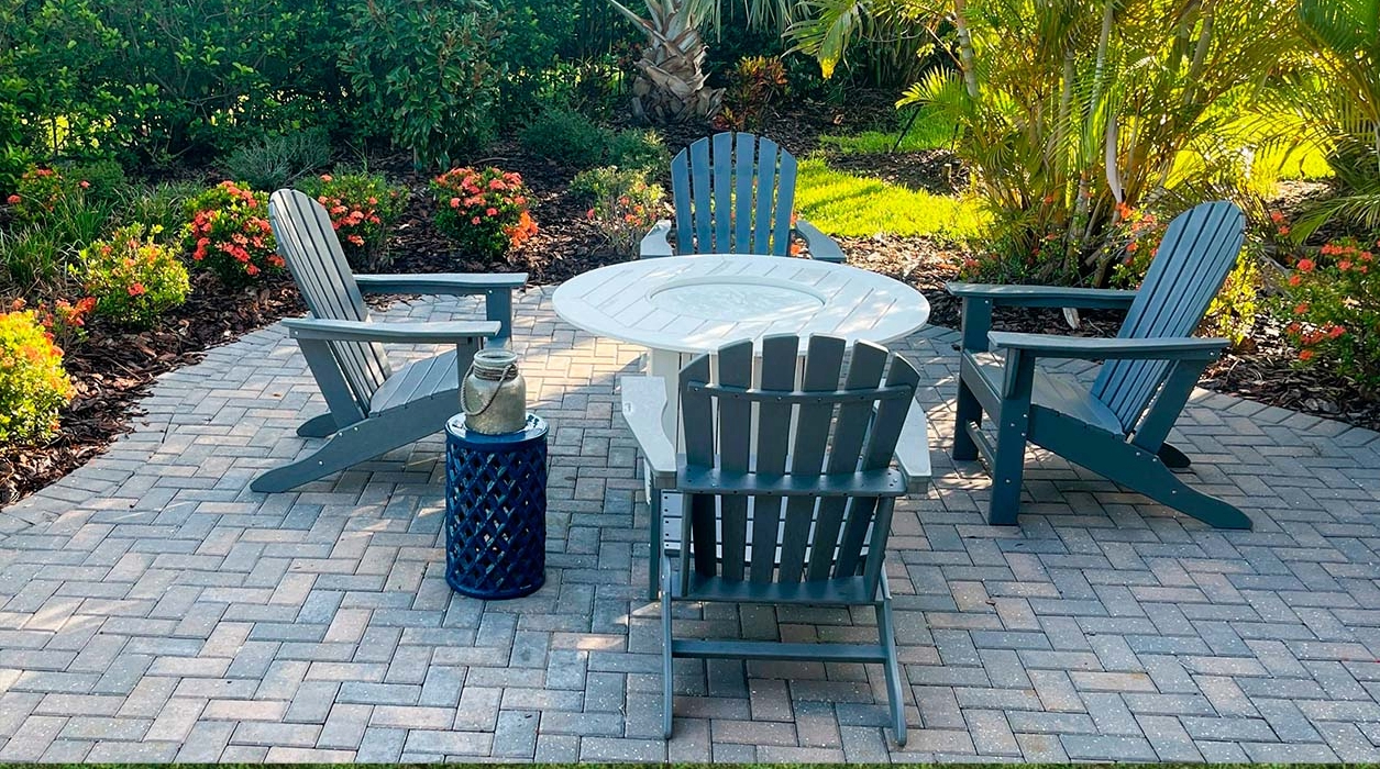 A completed circular stone seating area surrounded by tropical landscaping, showcasing the work of a skilled patio contractor.