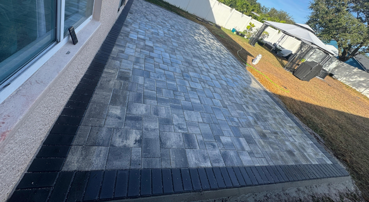 A newly installed marble-style stone surface extending from a residential home, reflecting the average cost of a paver patio.