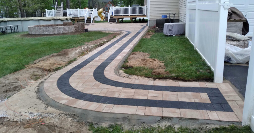 A curved residential path with a dark border, demonstrating a key design phase in how to install a paver walkway.