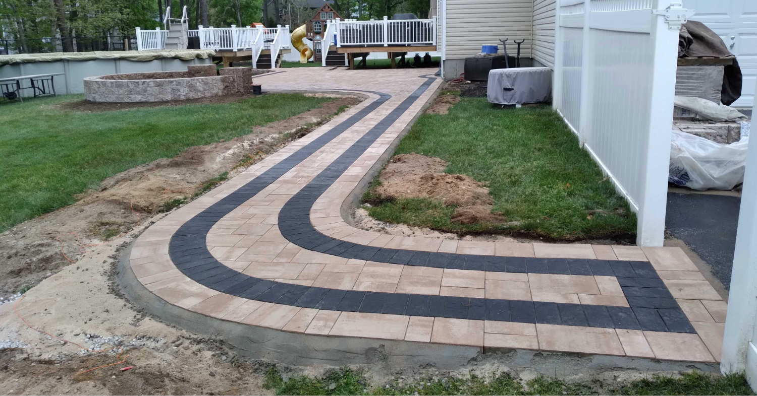A curved residential path with a dark border, demonstrating a key design phase in how to install a paver walkway.
