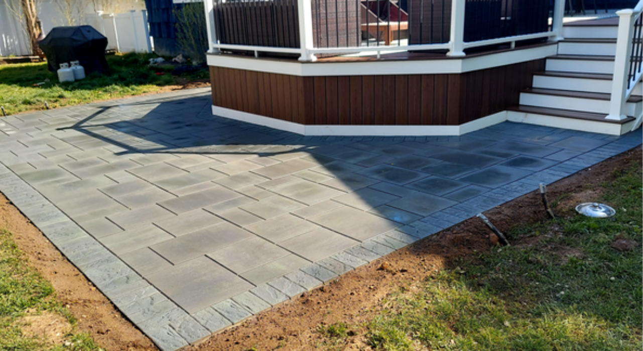 A visual comparison between a smooth grey surface and textured stones, highlighting the choice of concrete vs paver patio.
