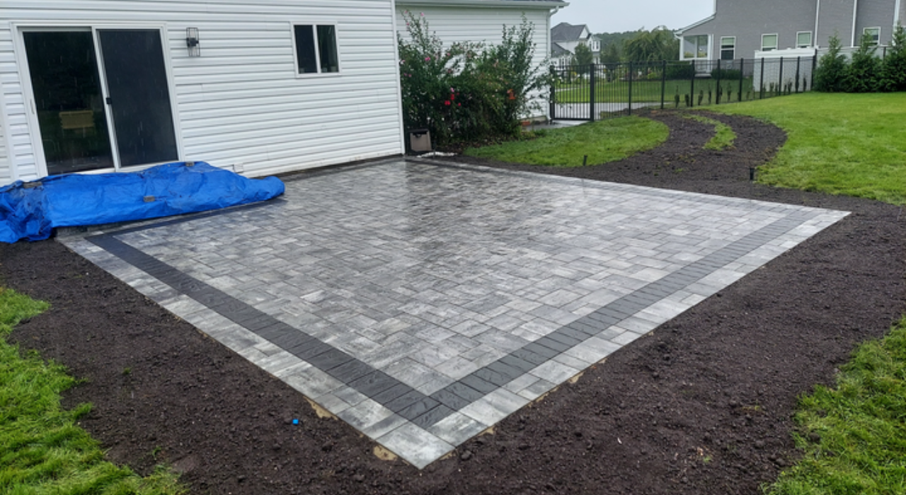 Using professional tools to ensure a flat surface and straight lines when learning how to install patio pavers for home.