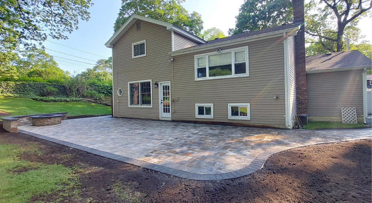 Crushed stone layered and compacted across a backyard site to create a durable, professional-grade patio paver base.