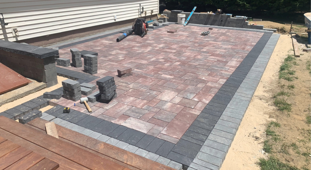Active construction site showing base prep and borders, essential labor steps in the cost to install a brick paver patio.