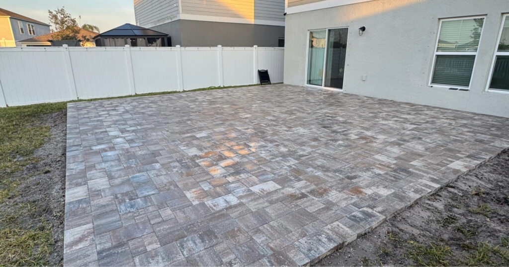 Laying simple concrete pavers directly over flat leveled dirt is widely considered the cheapest way to build a patio easily.