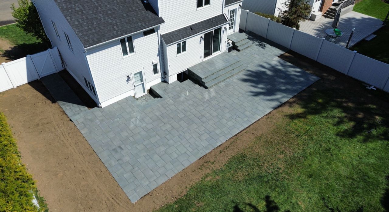 custom paver patio installation layout with paver samples, furniture spacing, and backyard traffic flow
