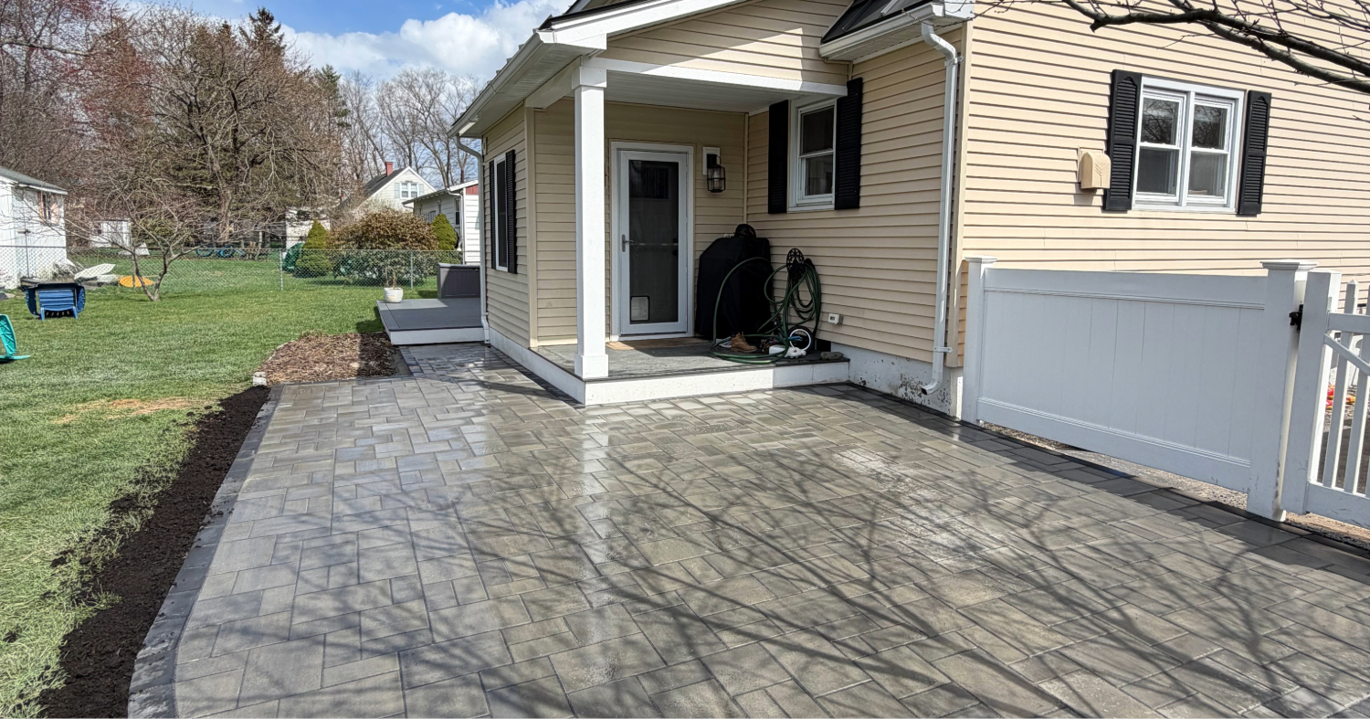 This beautifully curved stone edge highlights the high quality materials and labor that determine your paver patio cost in Manchester.
