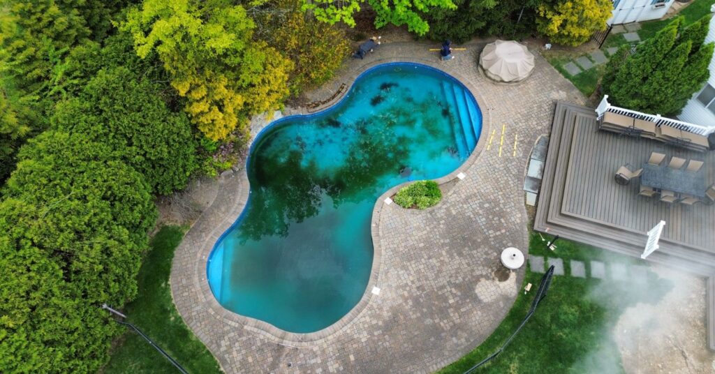 Pavers around above ground pool with clean poolside walkway, proper slope, and backyard patio layout