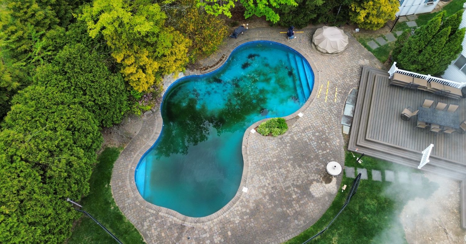 Pavers around above ground pool with clean poolside walkway, proper slope, and backyard patio layout