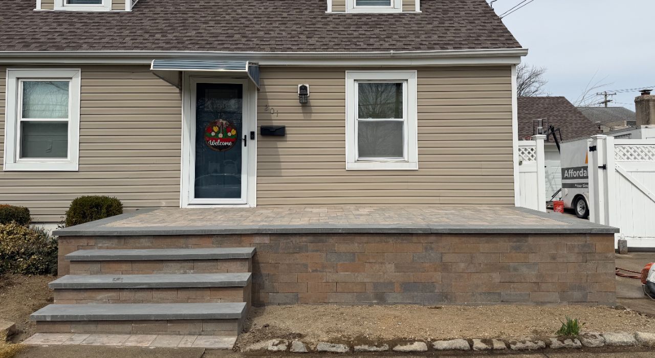 retaining wall installation with concrete footing, drainage stone, filter fabric, and Long Island soil conditions