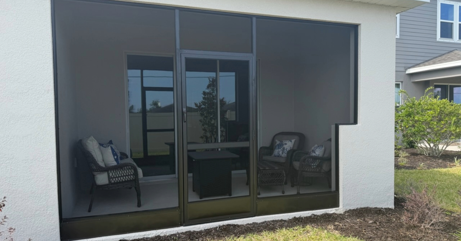 A cozy furnished patio set up inside a completed diy lanai screen enclosure.