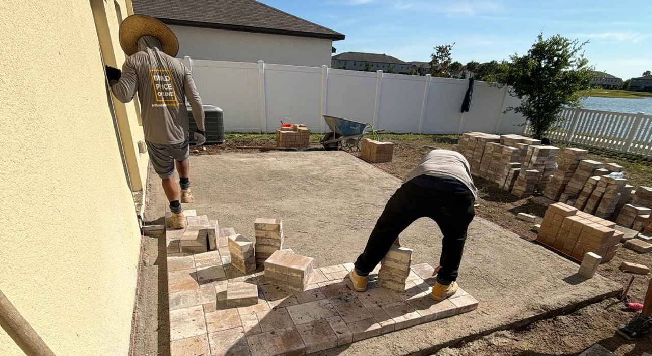 Contractors laying outdoor stones, demonstrating how to install a walkway with pavers.