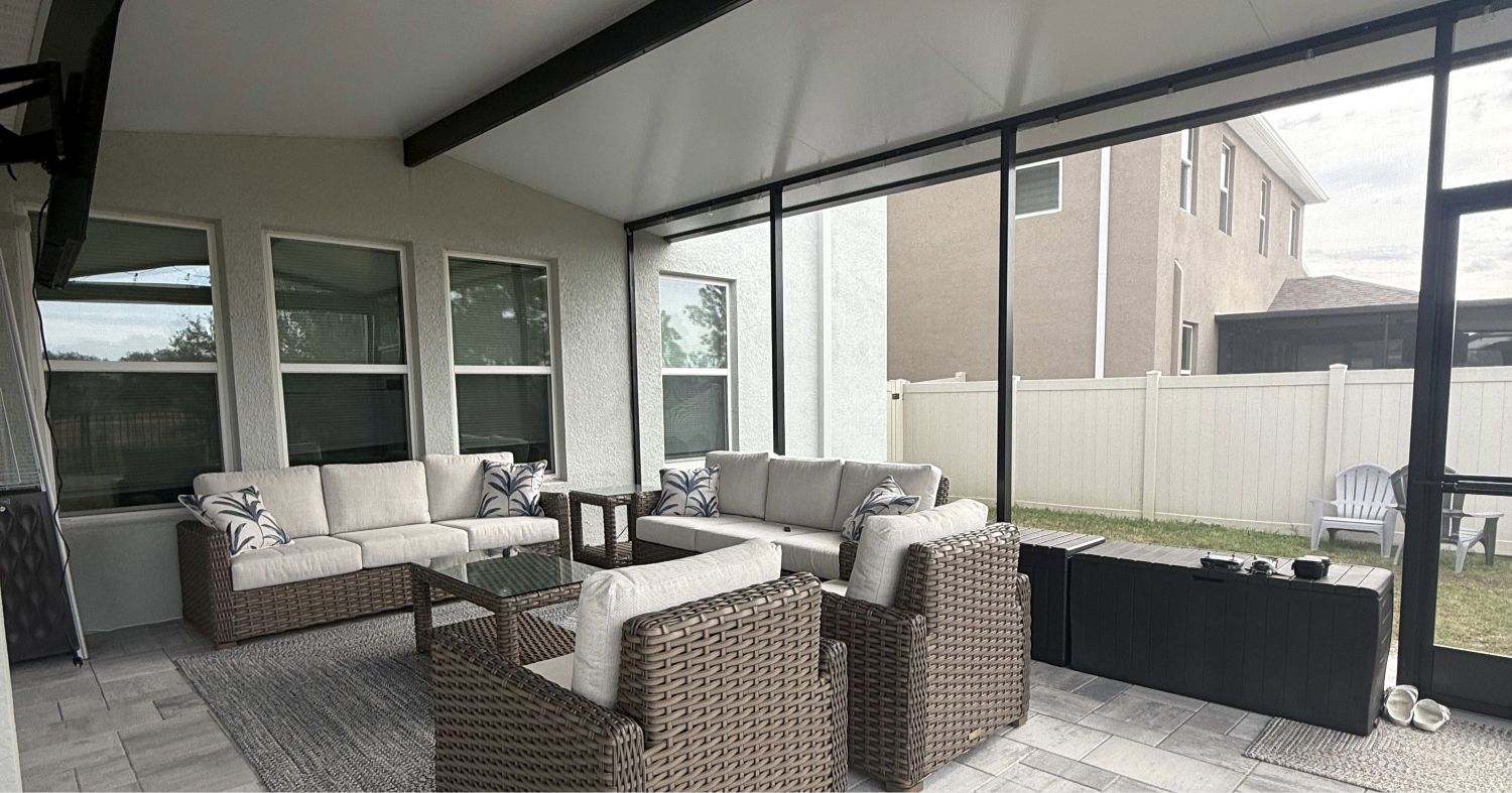 A modern outdoor living space with patio furniture built using lanai enclosure kits.