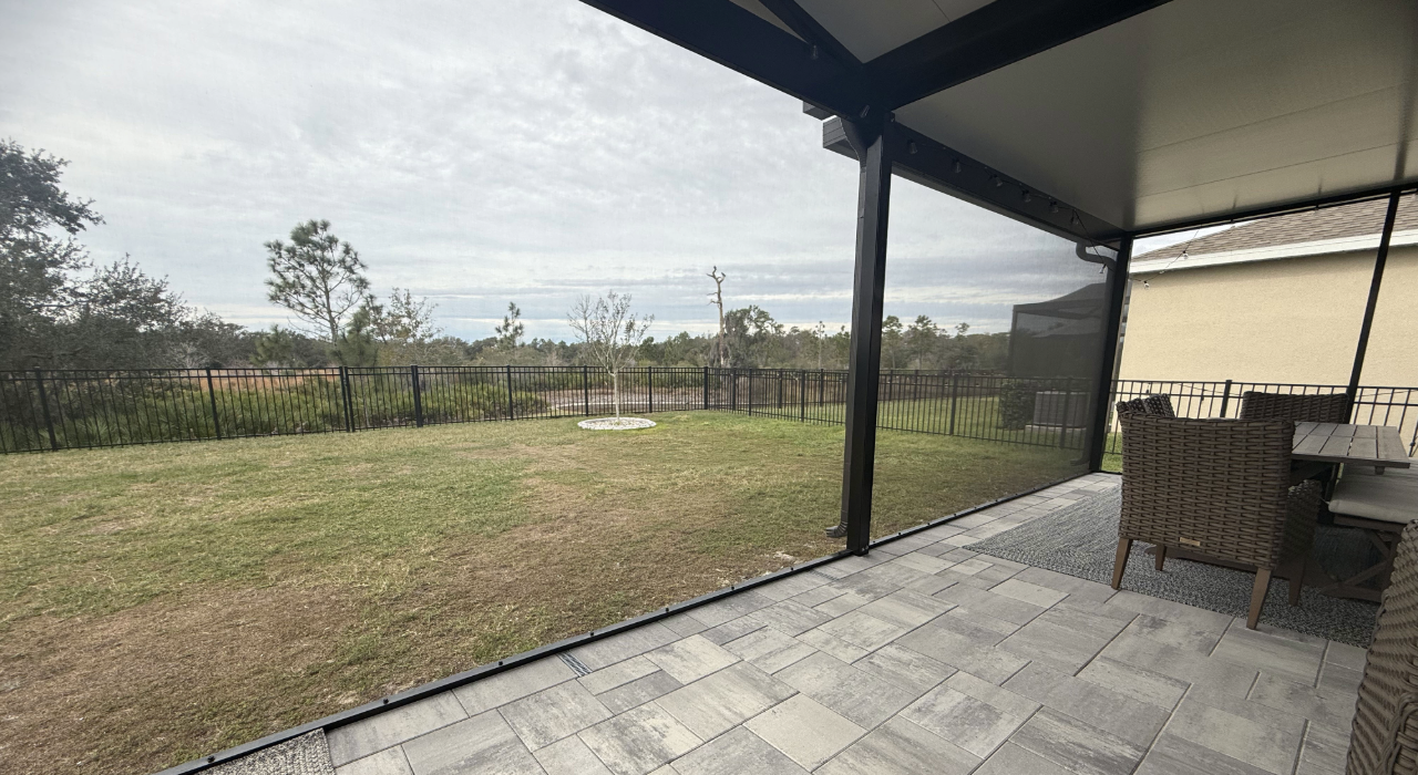 A worker grading dirt outside a home preparing for a diy lanai screen enclosure.