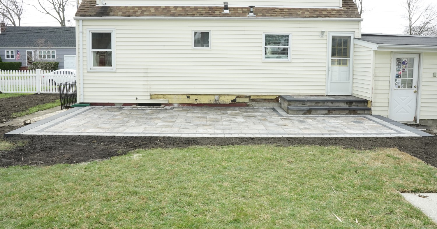 A clean backyard stone patio built by a reliable patio contractor in Concord.