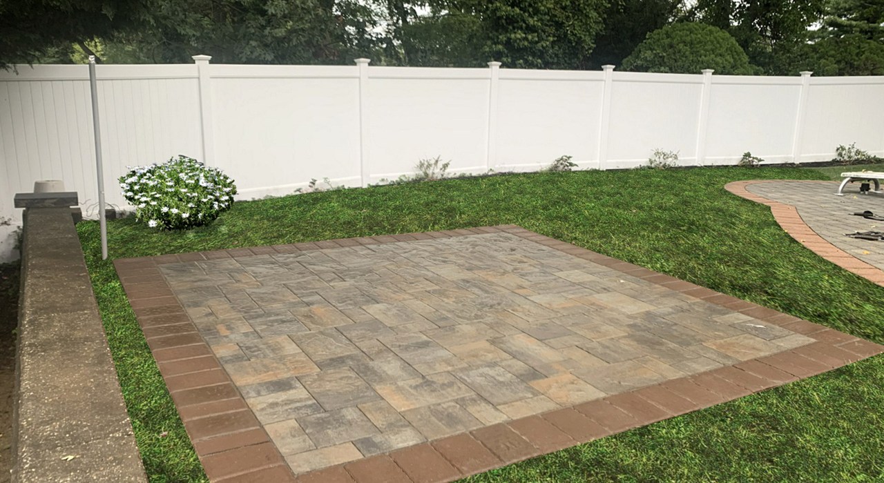 A square paver pad in a fenced backyard ideal for patio covers on Long Island.