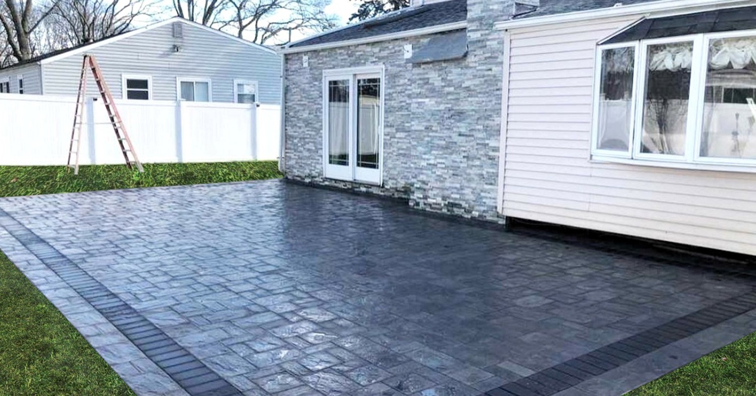 A stunning, completed dark grey paver patio installation in Concord next to a house.