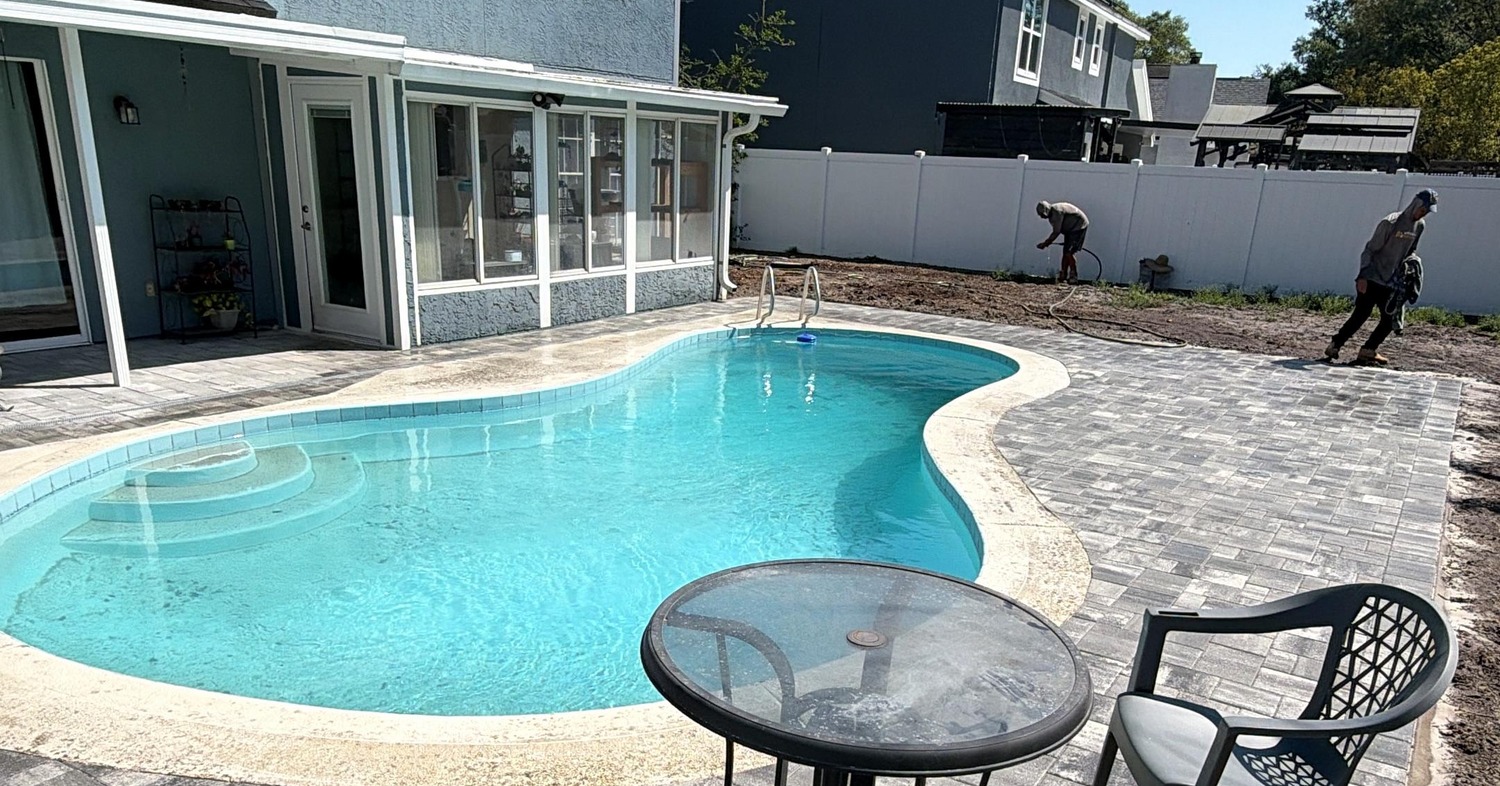 Swimming pool deck showing the aesthetic of a paver patio vs stamped concrete.