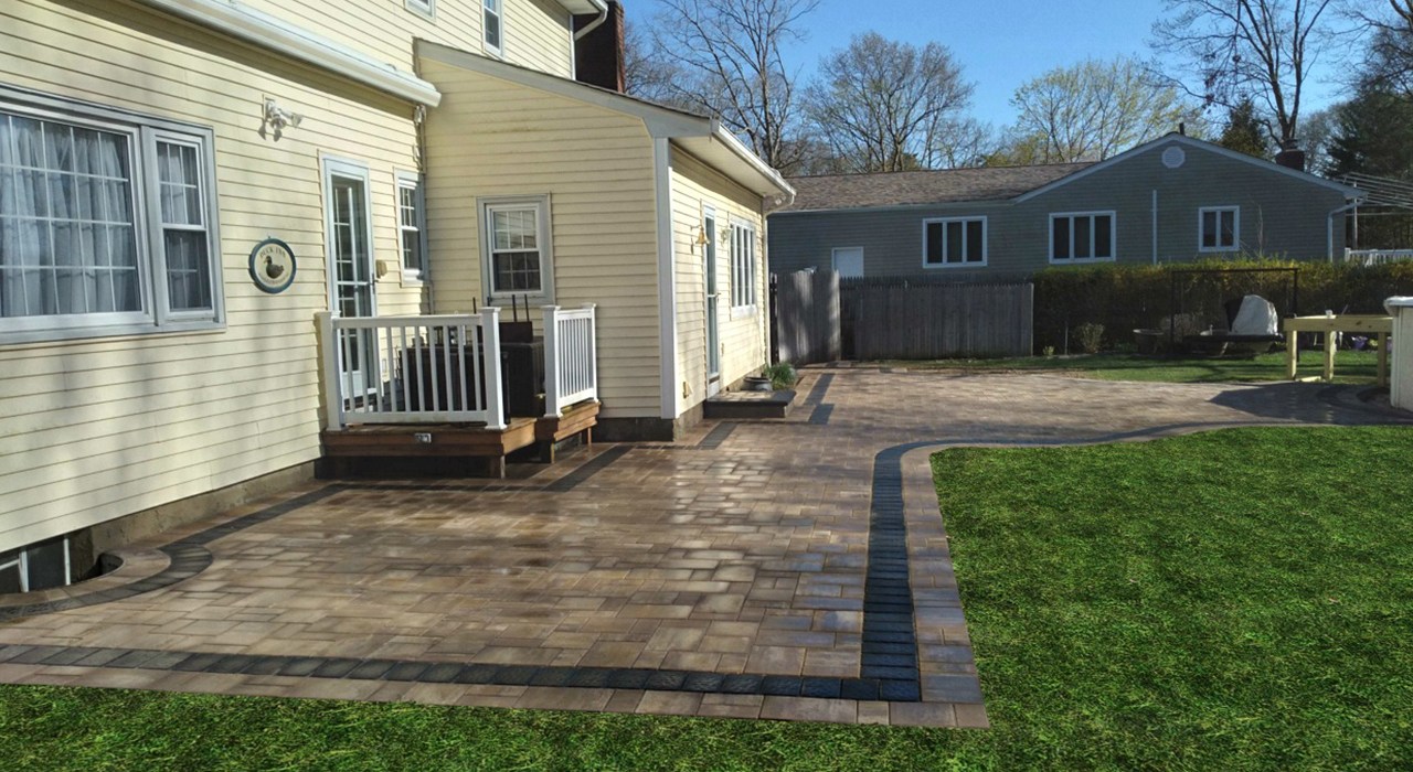Properly leveled stone paving alongside a house showing why paver patios sink without support