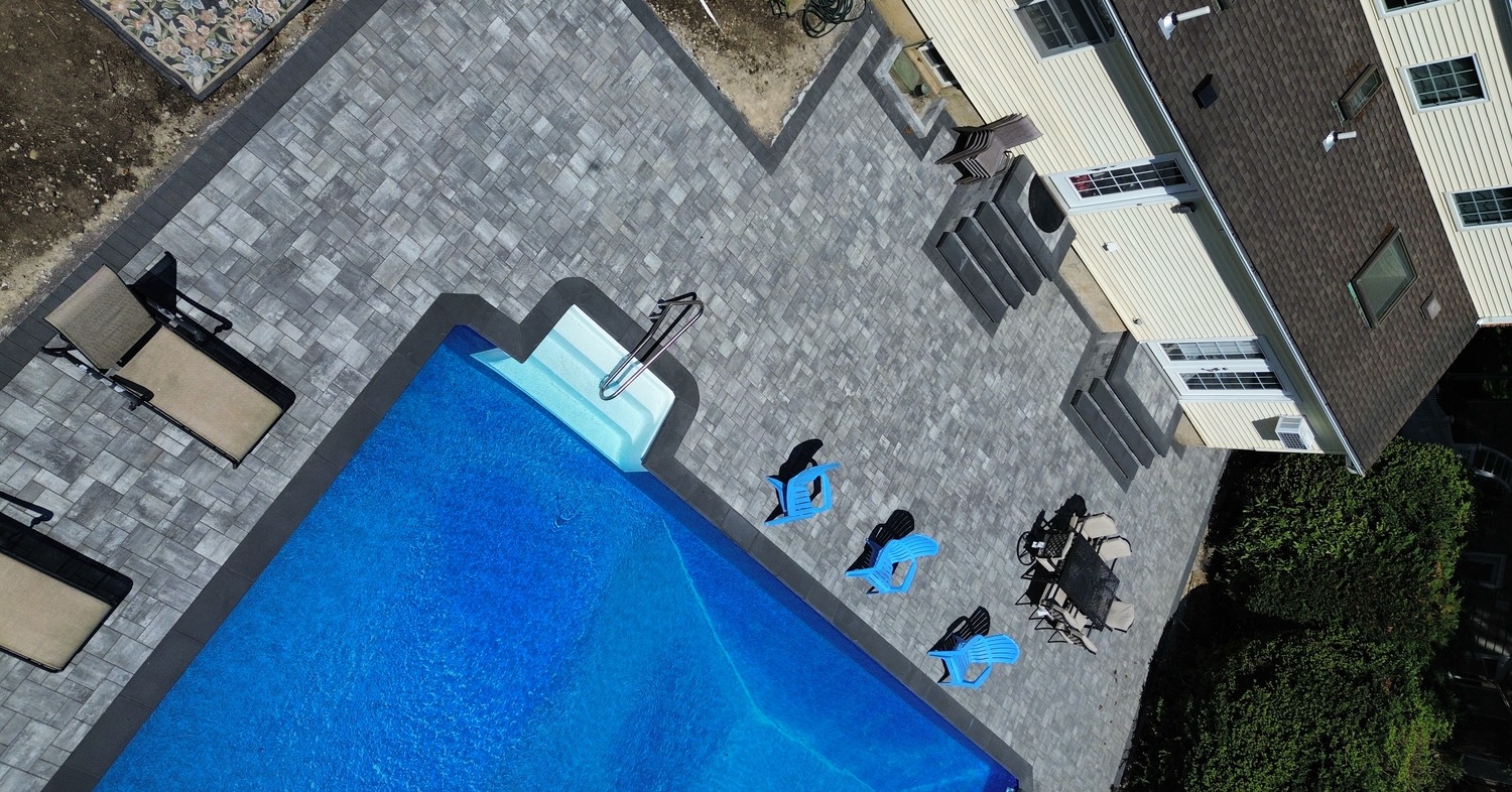 A custom backyard swimming pool design showcasing pool patio ideas for Concord.