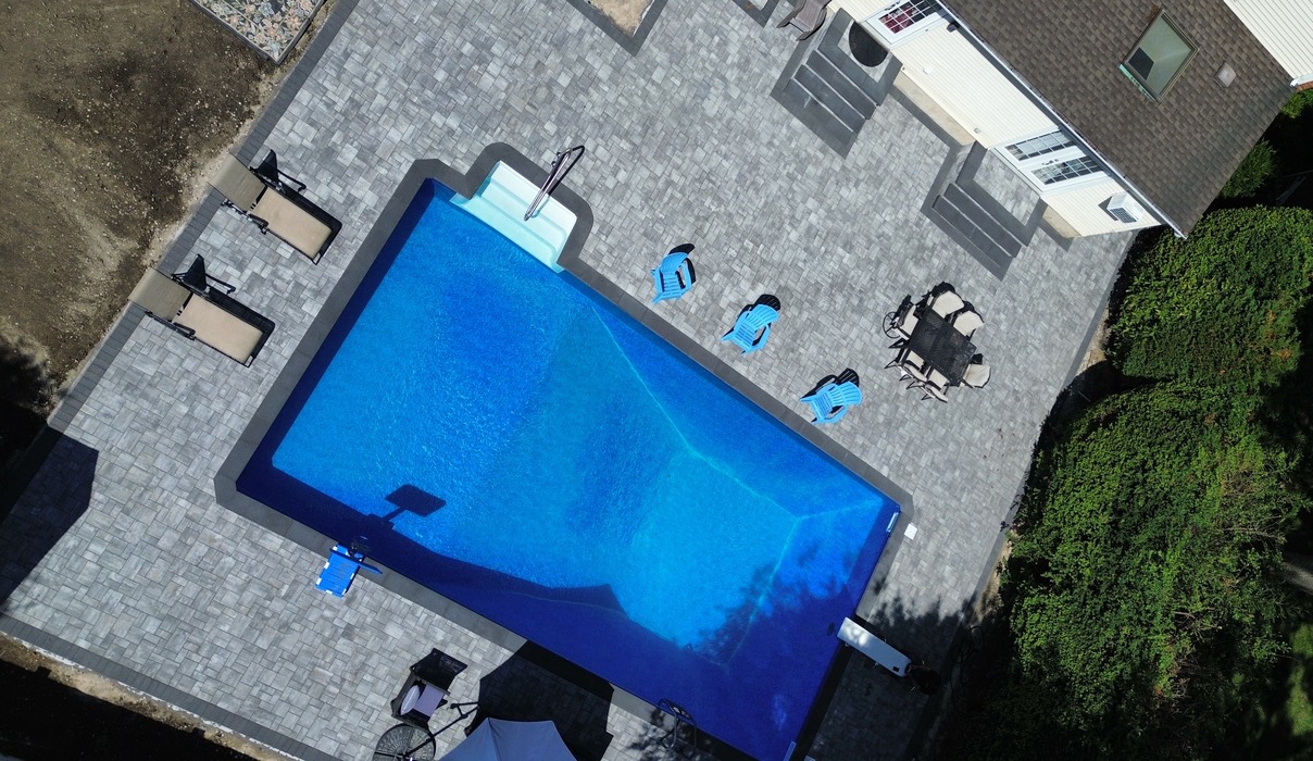 "An aerial view of a paver deck offering pool patio ideas for Concord.