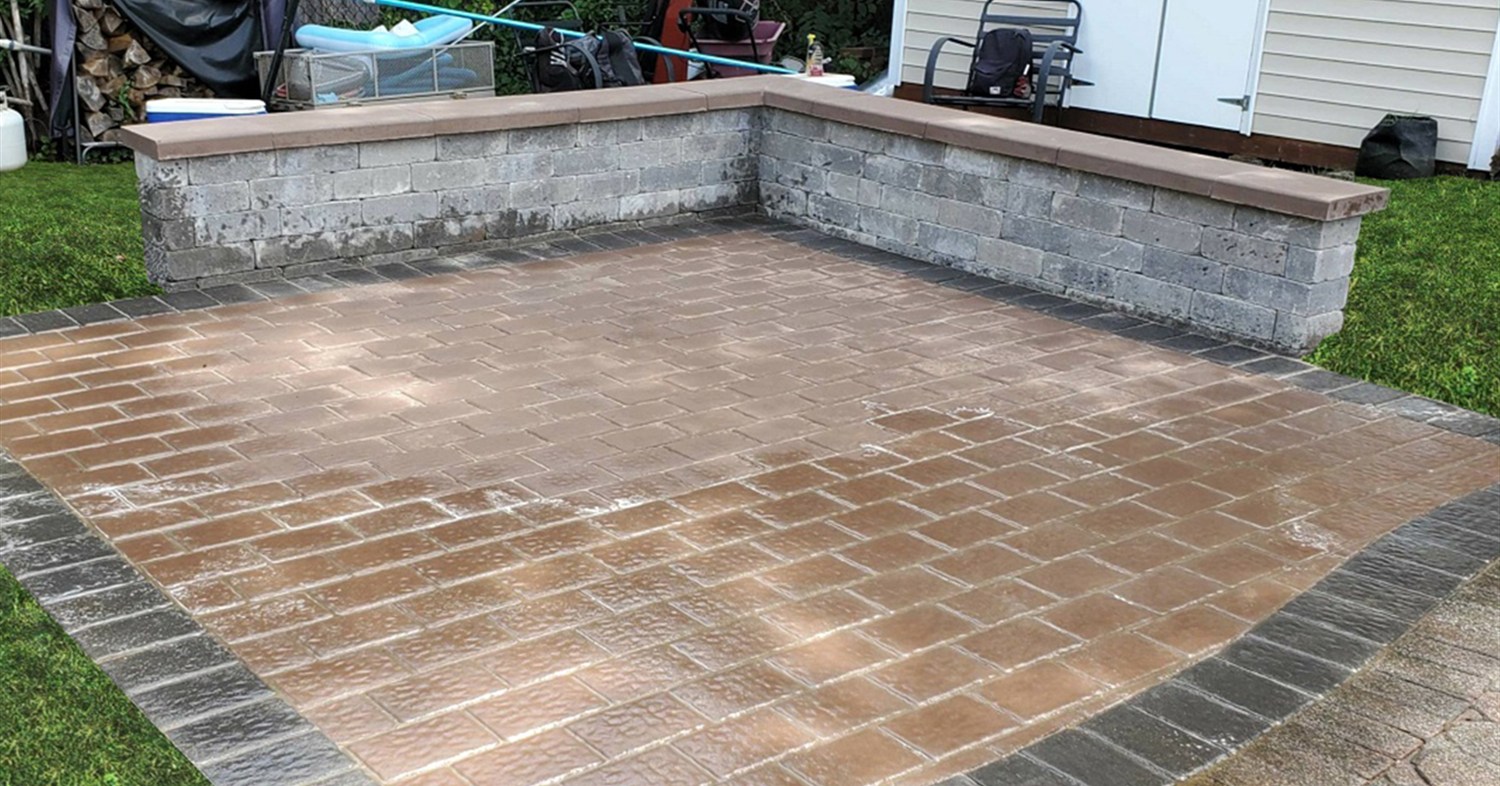 A corner retaining stone bench on a paver patio offering modern seating wall ideas